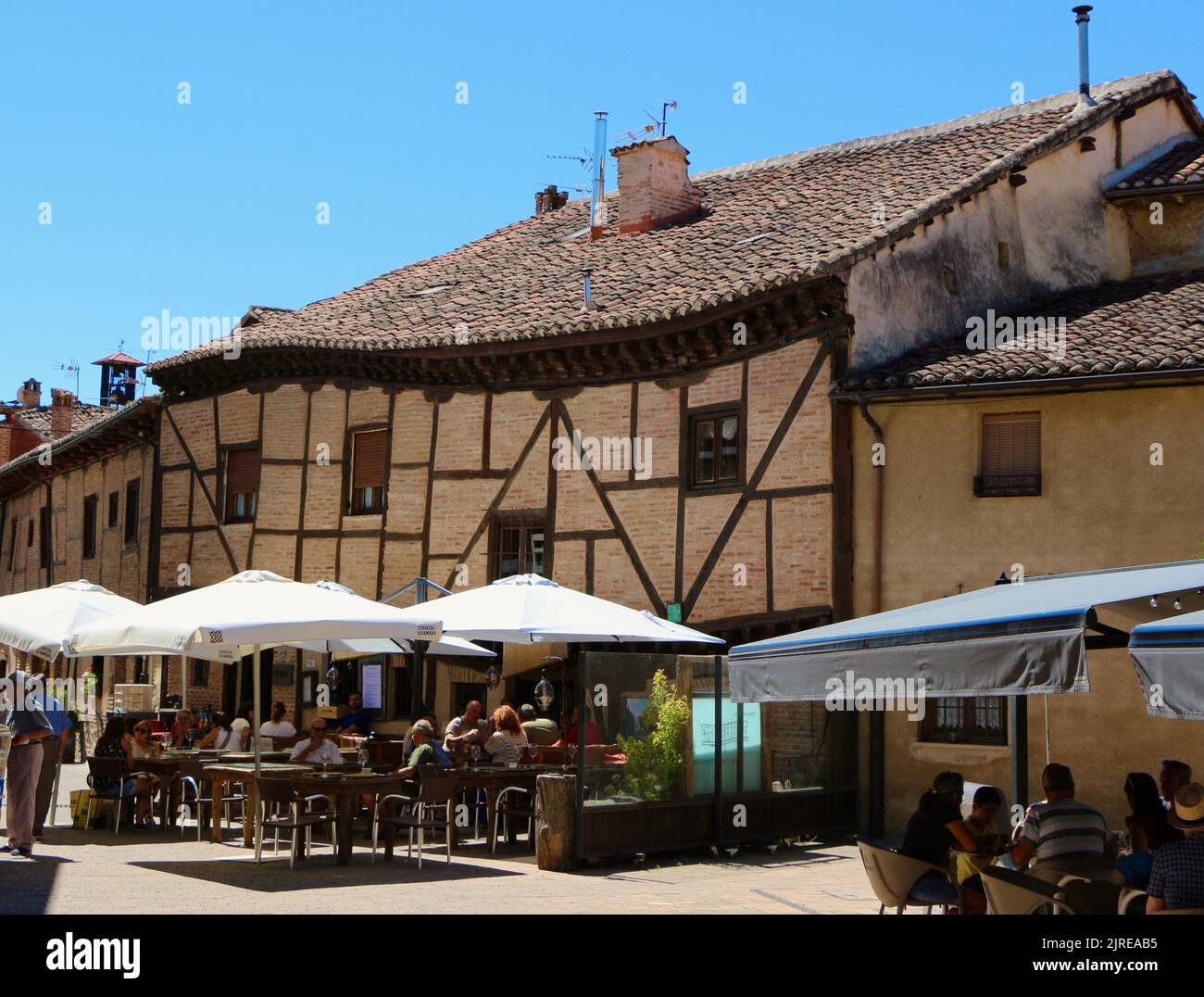 Terrace outside the Crooked house restaurant at lunchtime on a hot August day Saldaña Palencia Castile and Leon Spain Stock Photo
