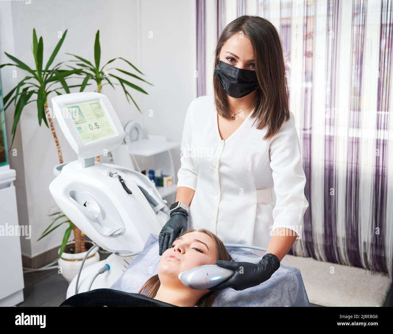 Specialist in the field of aesthetic medicine performing ultrasonic non-surgical facelift procedure for woman. SMAS lifting - great alternative to plastic surgery. Stock Photo