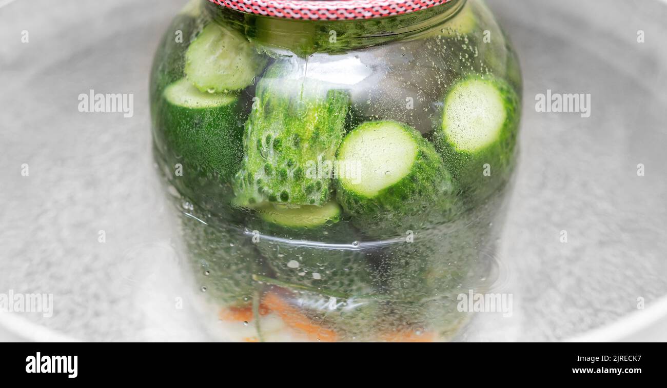 A jar of cucumbers is cooked in a pot of boiling water Stock Photo Alamy