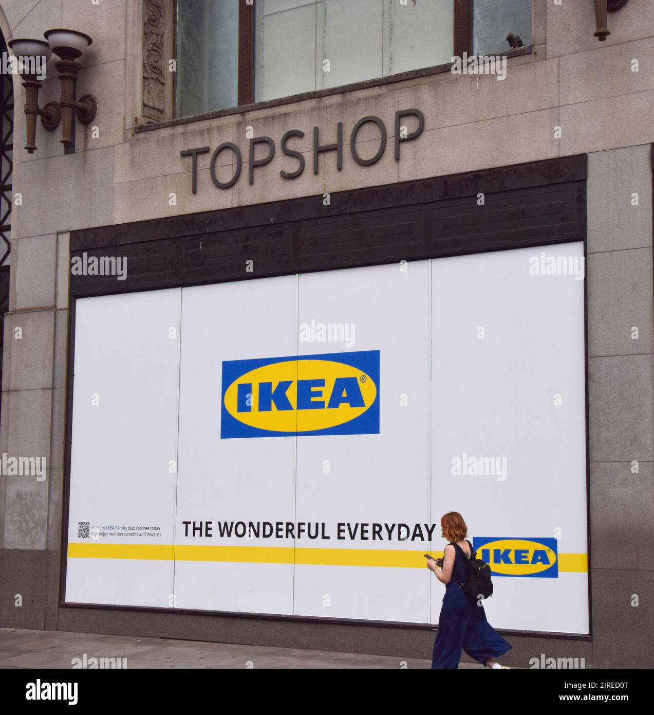 London, UK. 24th August 2022. A woman walks past the shop window of the