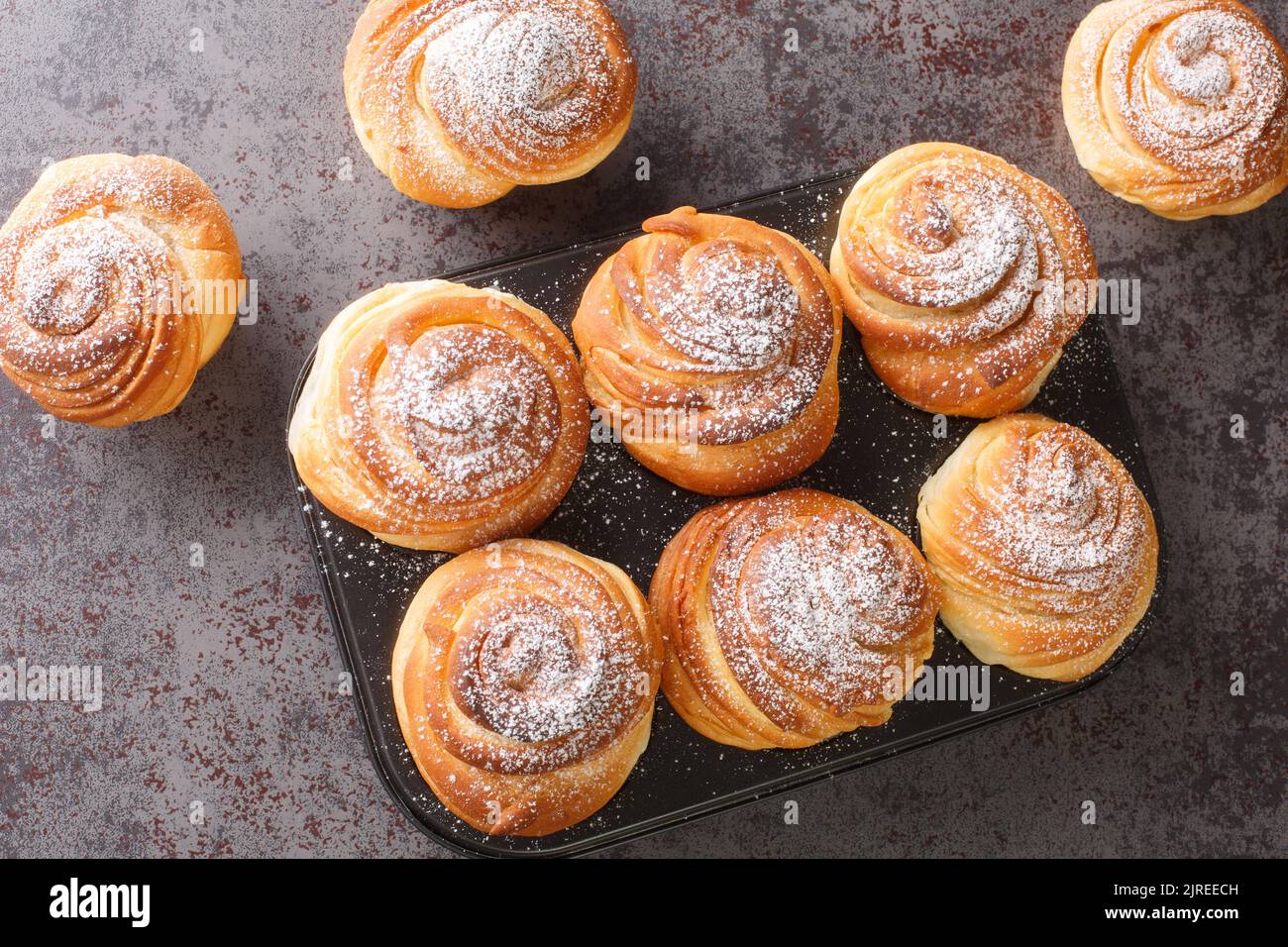 Homemade pastries cruffins, muffin with sugar powder, on dark background, selective focuse close up. Horizontal top view from above Stock Photo