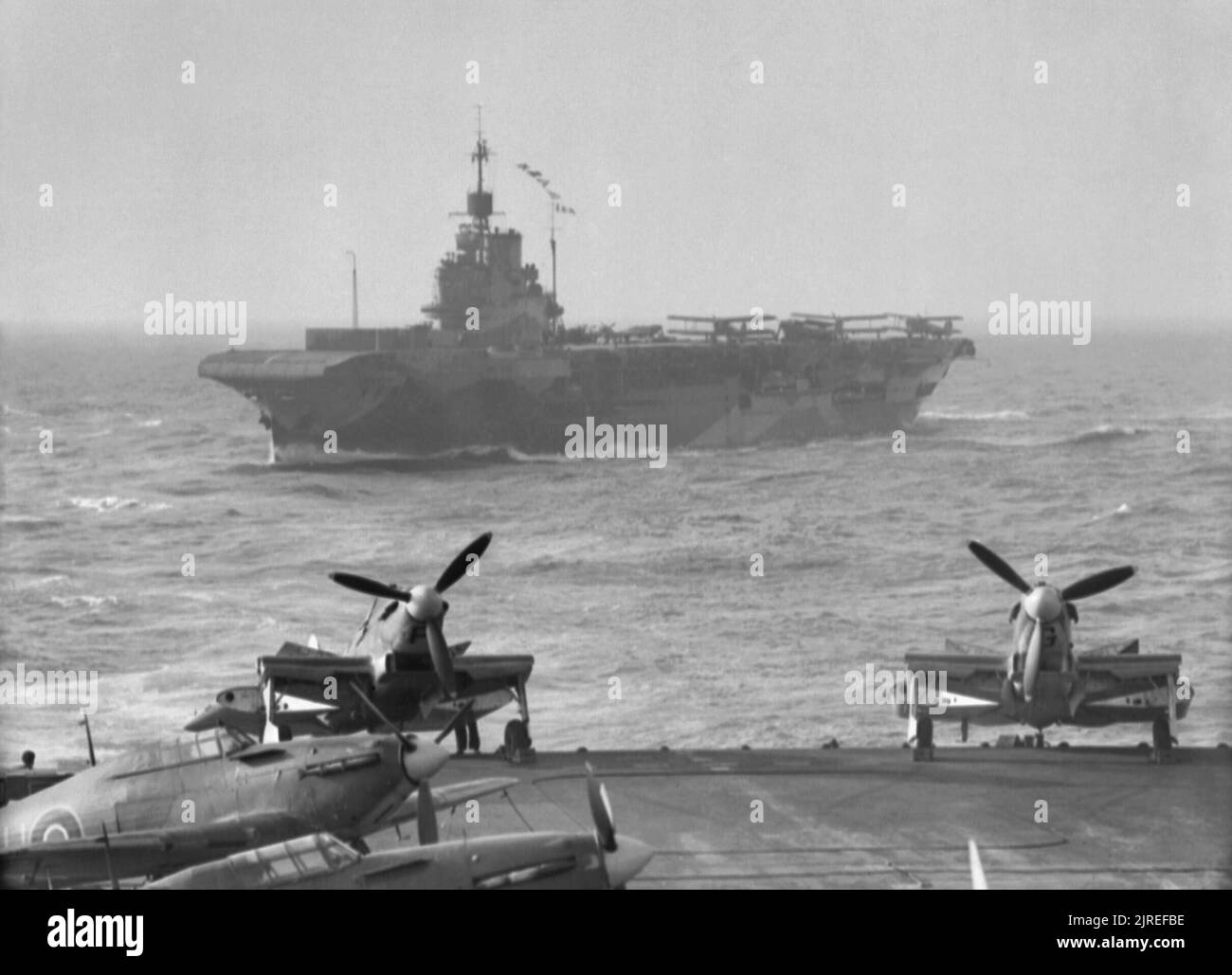 Operation Pedestal, August 1942 12 August: The bombing of HMS INDOMITABLE: HMS INDOMITABLE manoeuvring astern of HMS VICTORIOUS. Stock Photo