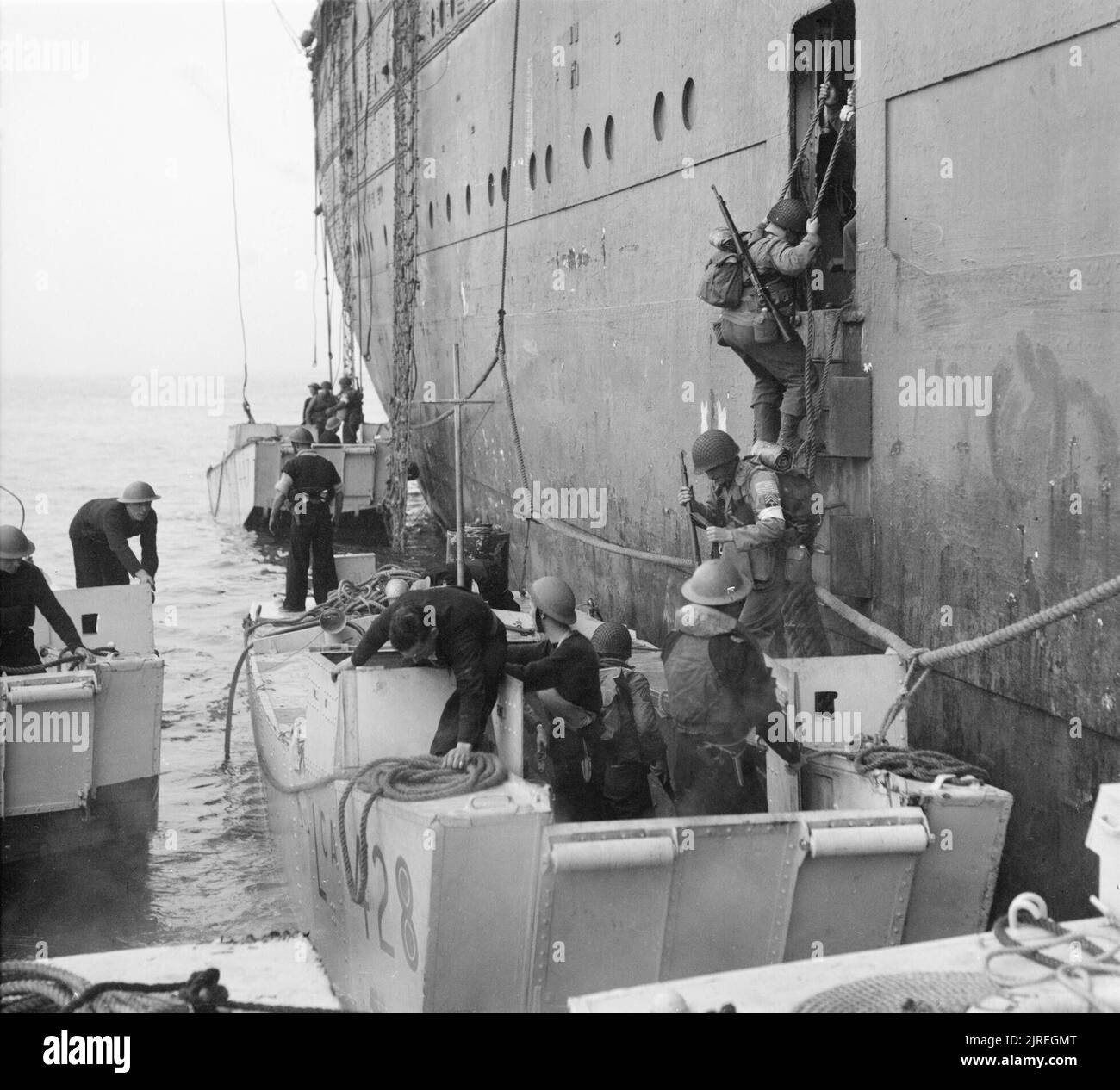 American troops climb into assault landing craft from the liner REINA