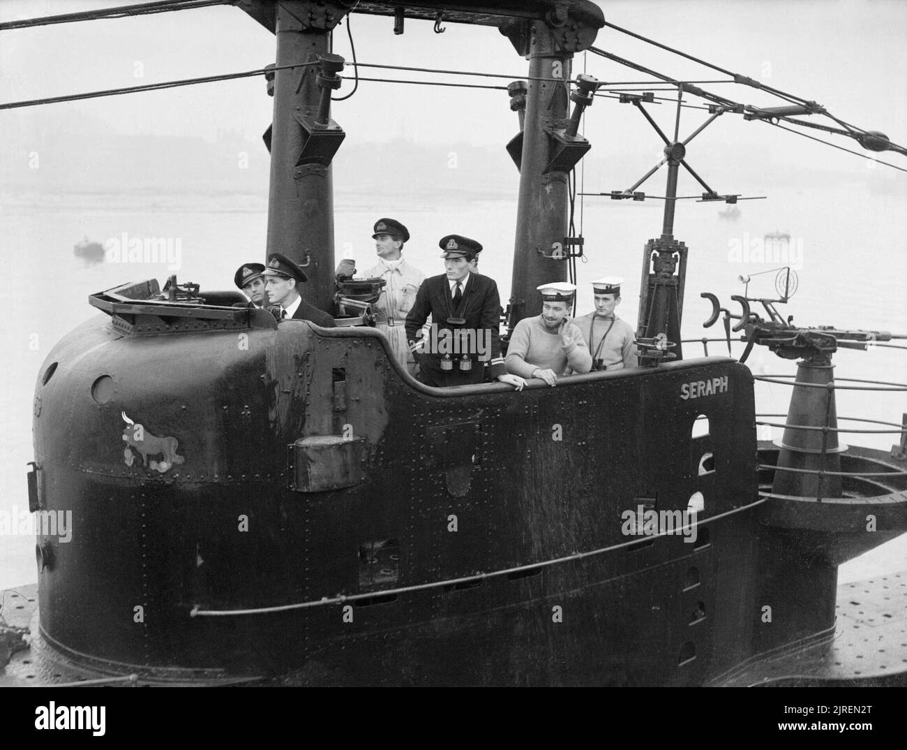 The Royal Navy during the Second World War HMS SERAPH arriving home at Portsmouth after 13 busy months. On the bridge, left to right: Lieutenant F G Harris, RNVR, of Sale, Cheshire; Lieutenant N L A Jewell, of Pinner, Middlesex, the Commanding Officer Warrant Engineer M M Stevenson, DSC, RN, of Glasgow, Scotland, the Engineer Officer; and Lieutenant W D Scott, RN, the First Lieutenant. Note the 20mm anti aircraft gun aft of the conning tower. Stock Photo