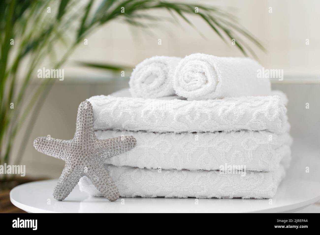 Rolled white towels in the bathroom or a spa salon, close up Stock Photo