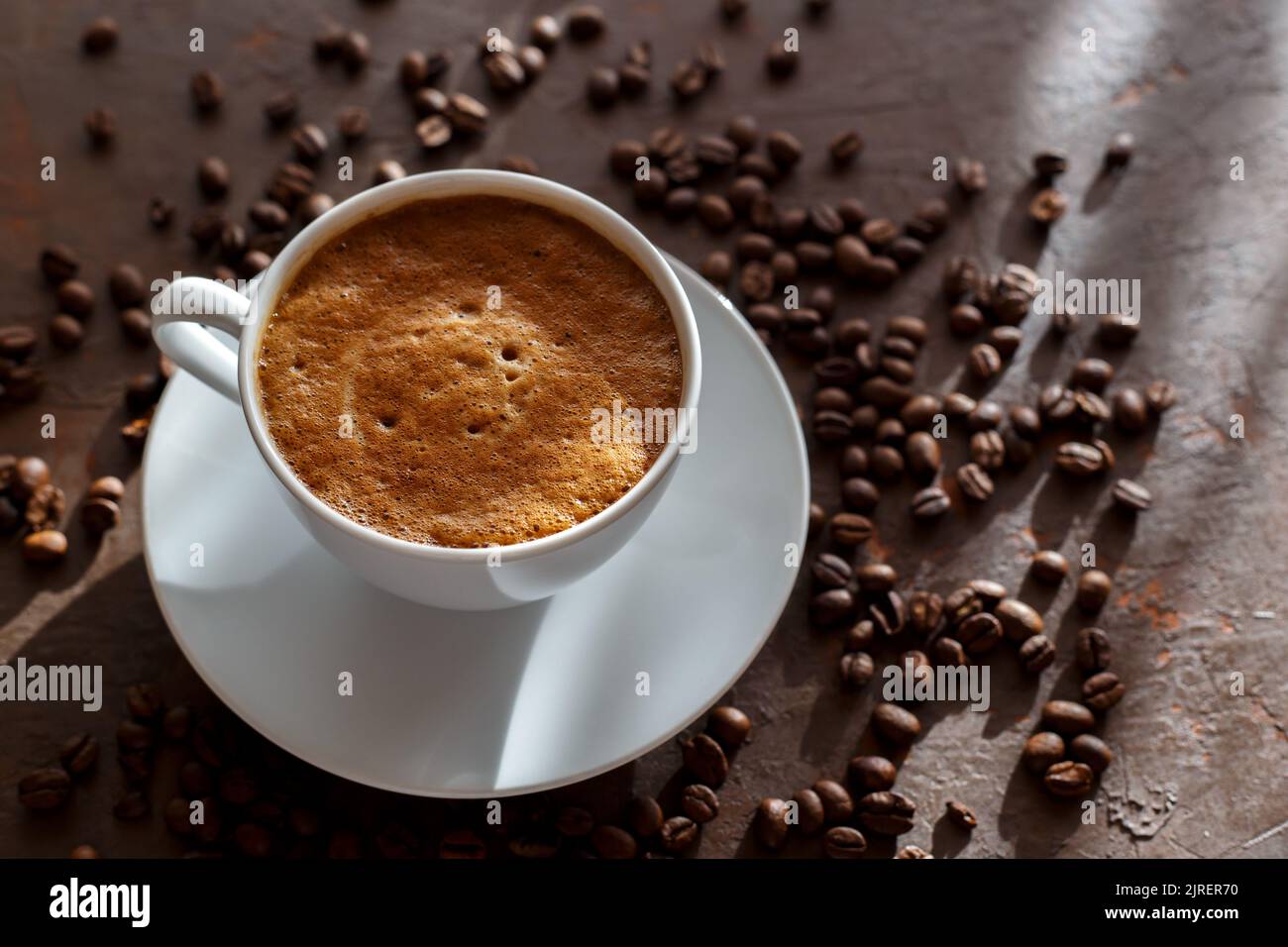 Cup of coffee cappuccino and coffee beans on the brown stone background Stock Photo