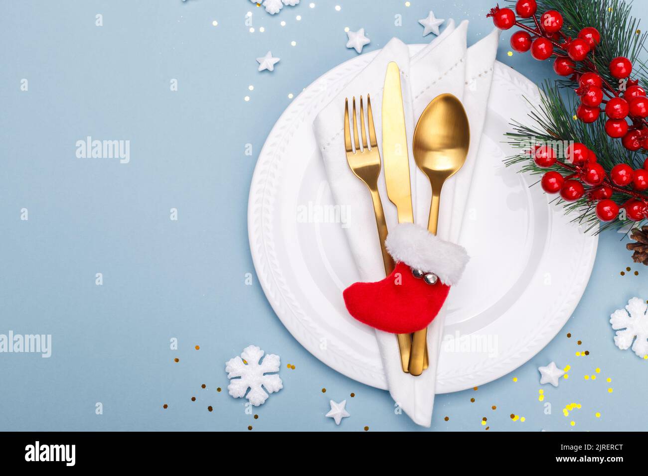 Christmas or new year table setting with golden cutlery on the blue background with copy space Stock Photo