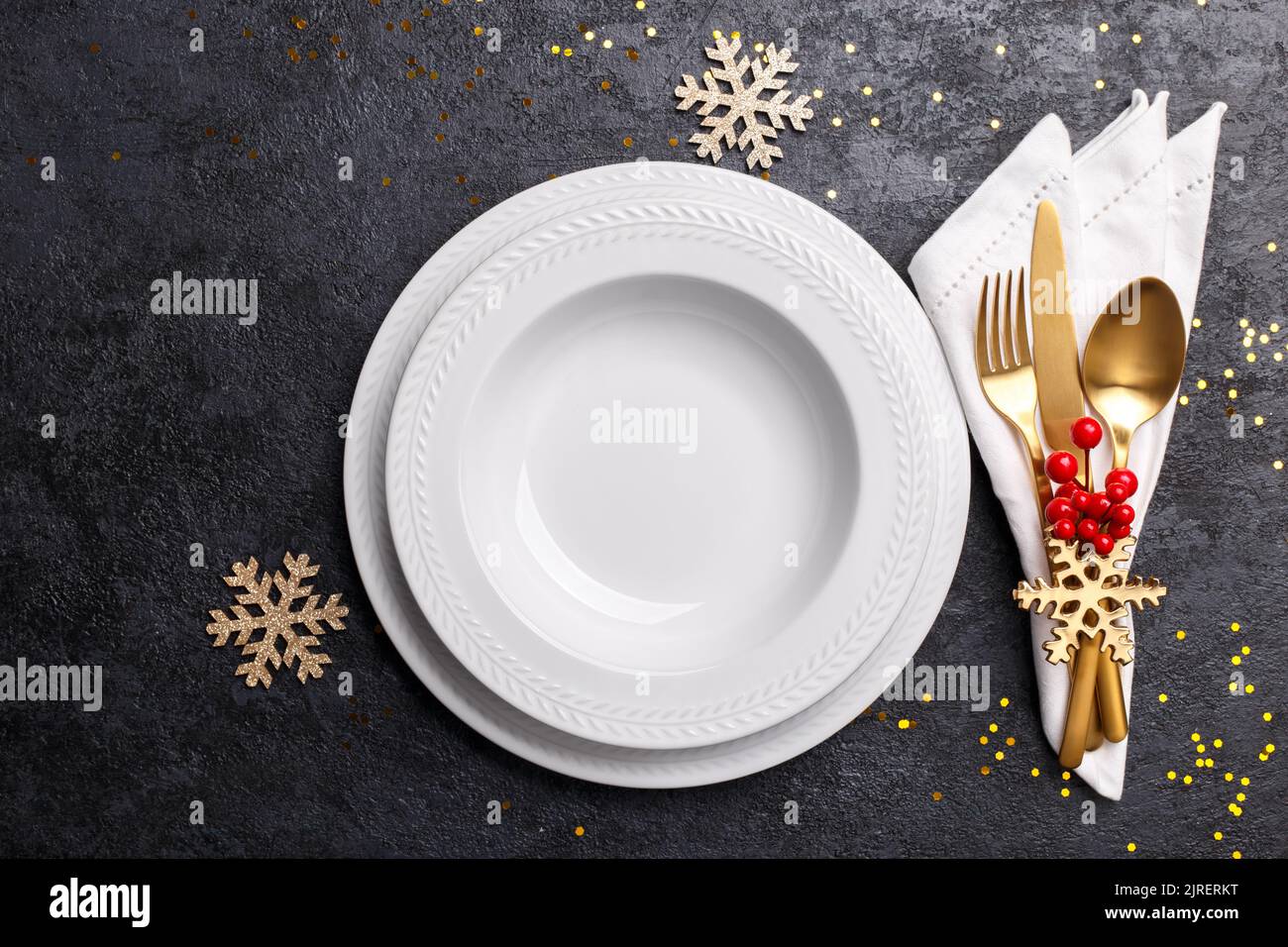 Christmas or new year table setting with golden cutlery on black stone table, card or menu template copy space flat lay Stock Photo