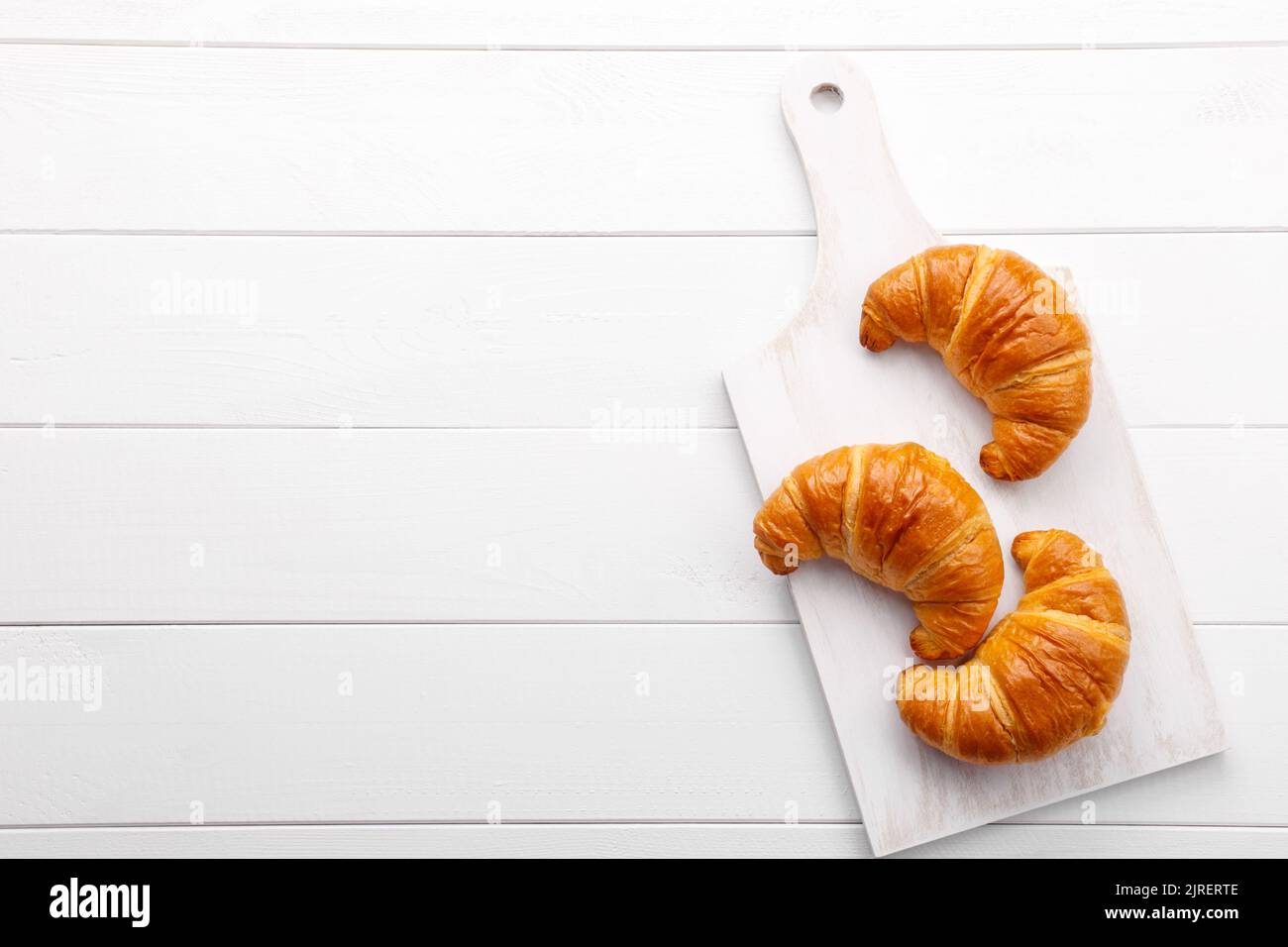 Traditional french croissant on white wooden table, tasty breakfast Stock Photo