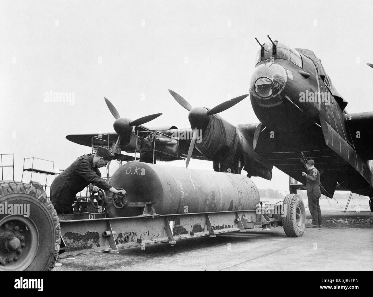 Royal Air Force Bomber Command, 1942-1945. Armourers prepare to load an 8,000-lb 'Super Cookie' HC bomb into a waiting Avro Lancaster. Stock Photo
