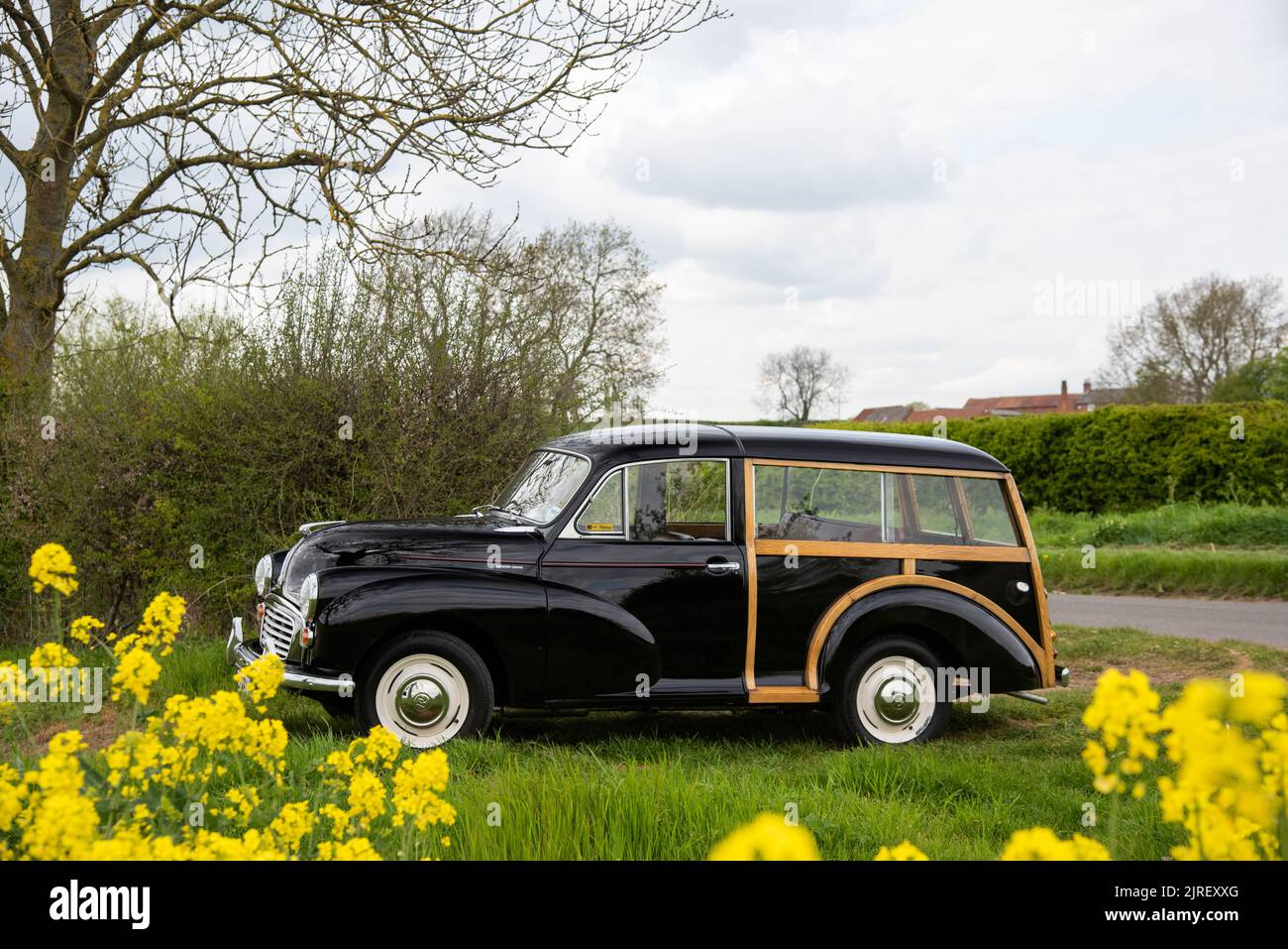 Morris Traveller parked on at the entrance to a field on a country lane in Derbyshire on a cloudy day in Spring Stock Photo