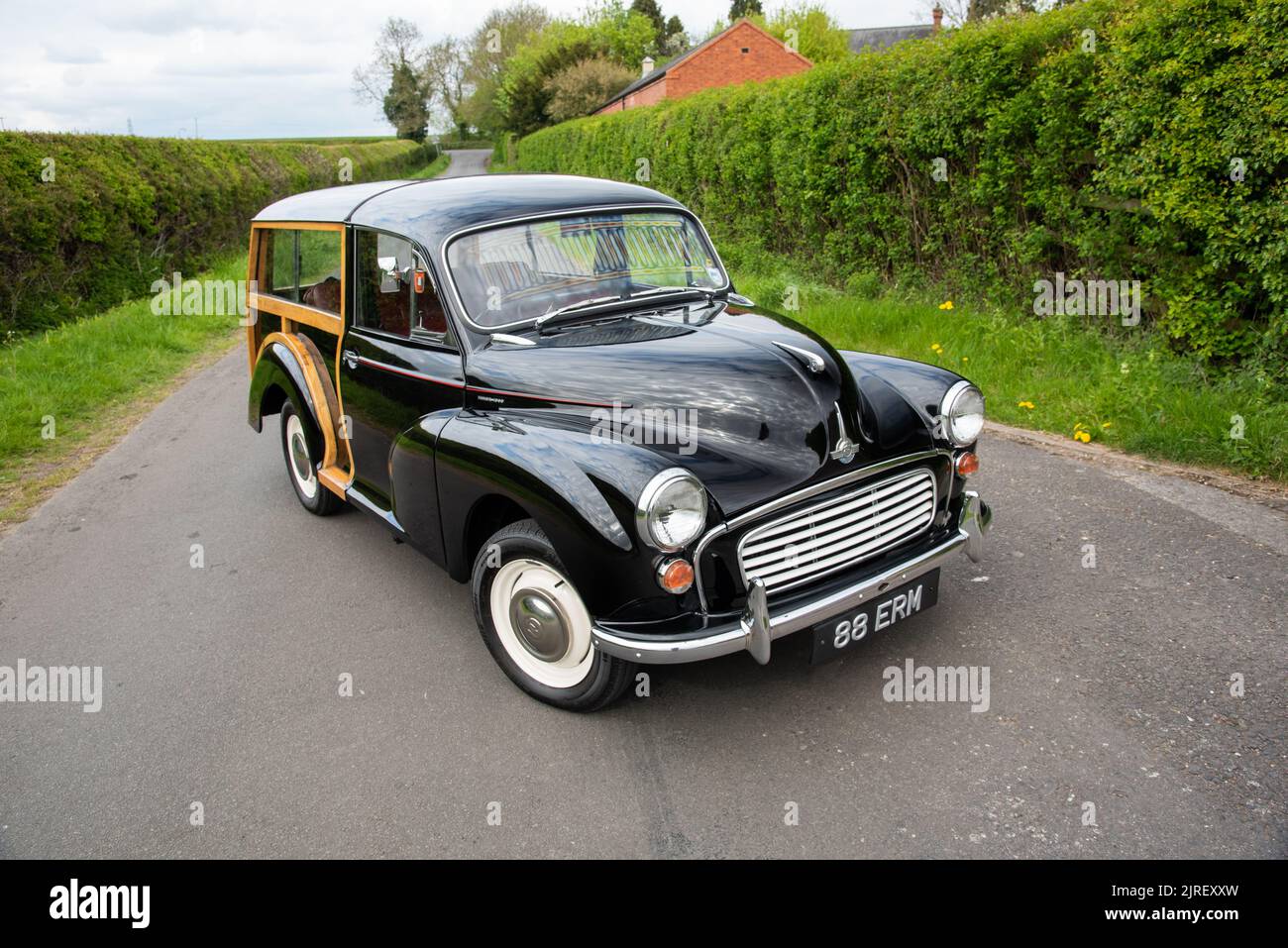 Morris Traveller parked on a country lane in Derbyshire on a cloudy day with tall hedges on either side Stock Photo