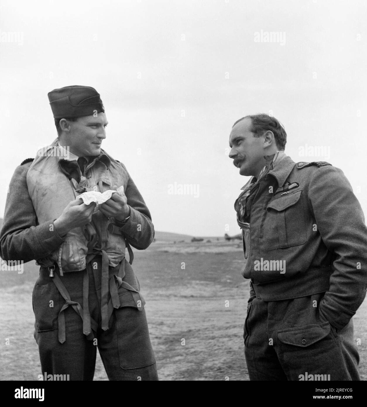 Royal Air Force Operations in the Middle East and North Africa, 1939-1943. Group Captain P H 'Dutch' Hugo (left), Commanding Officer of No. 322 Wing RAF, and Wing Commander R 'Raz' Berry, who took over leadership of the Wing in January 1943, conversing at Tingley, Algeria. Petrus Hendrik Hugo, a South African, joined the RAF on a short-service commission in February 1939. He flew with No. 615 Squadron RAF during the Battle of France and the Battle of Britain, and became a flight commander in September 1941. He was posted to command No. 41 Squadron RAF in November 1941, and then took over the l Stock Photo