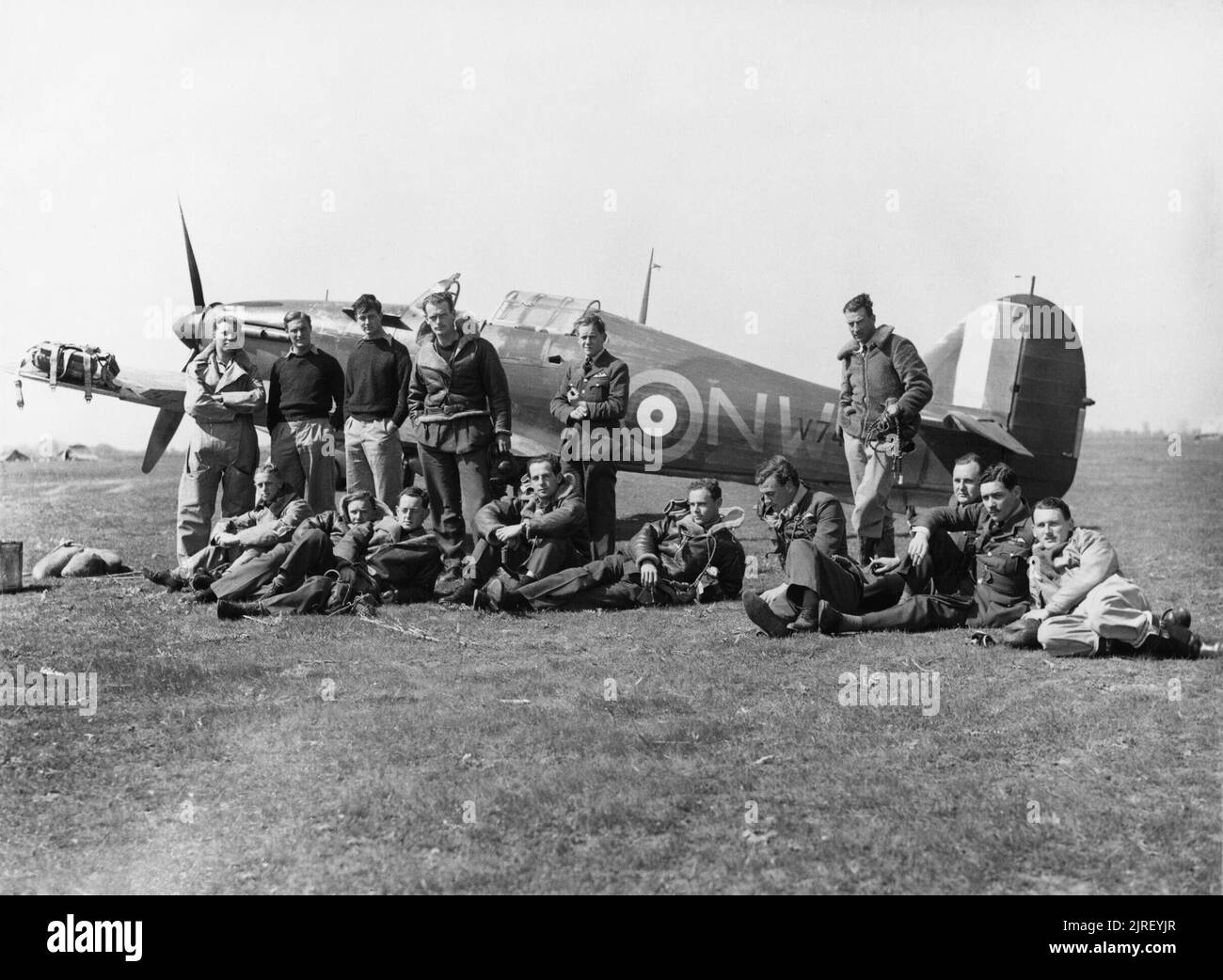 Royal Air Force Operations Over Albania and Greece, 1940-1941. Pilots of No. 33 Squadron RAF, at Larissa, Greece, with Hawker Hurricane Mark I, V7419, in background. Standing (left to right); Pilot Officers W Winsland, R Dunscombe (p.o.w 22 May 41), C A C Chetham (k.i.a. 15 April 41), and P R W Wickham, Flying Officers D T Moir and H J Starrett (died of burns 22 April 41): sitting (left to right); Flying Officer E J 'Timber' Woods (k.i.a. 17 June 41), Flying Officer F Holman (k.i.a. 20 May 41), Flight Lieutenant A M Young, Flying Officer V C 'Woody' Woodward, Squadron Leader M St J 'Pat' Pattl Stock Photo