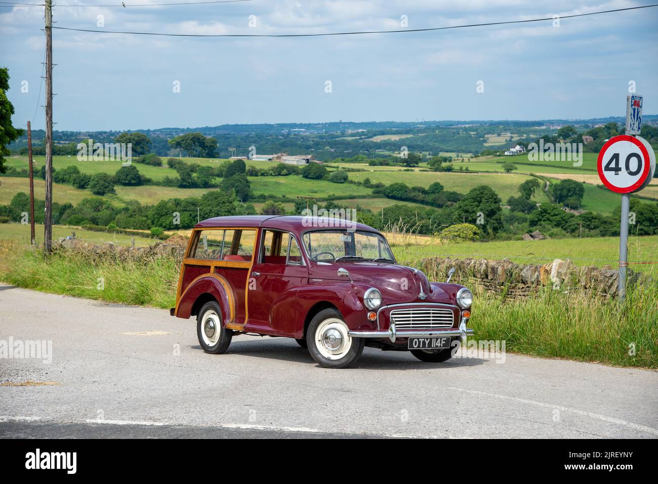 Morris Traveller parked on a country lane in Derbyshire on a summer day with farmland behind Stock Photo