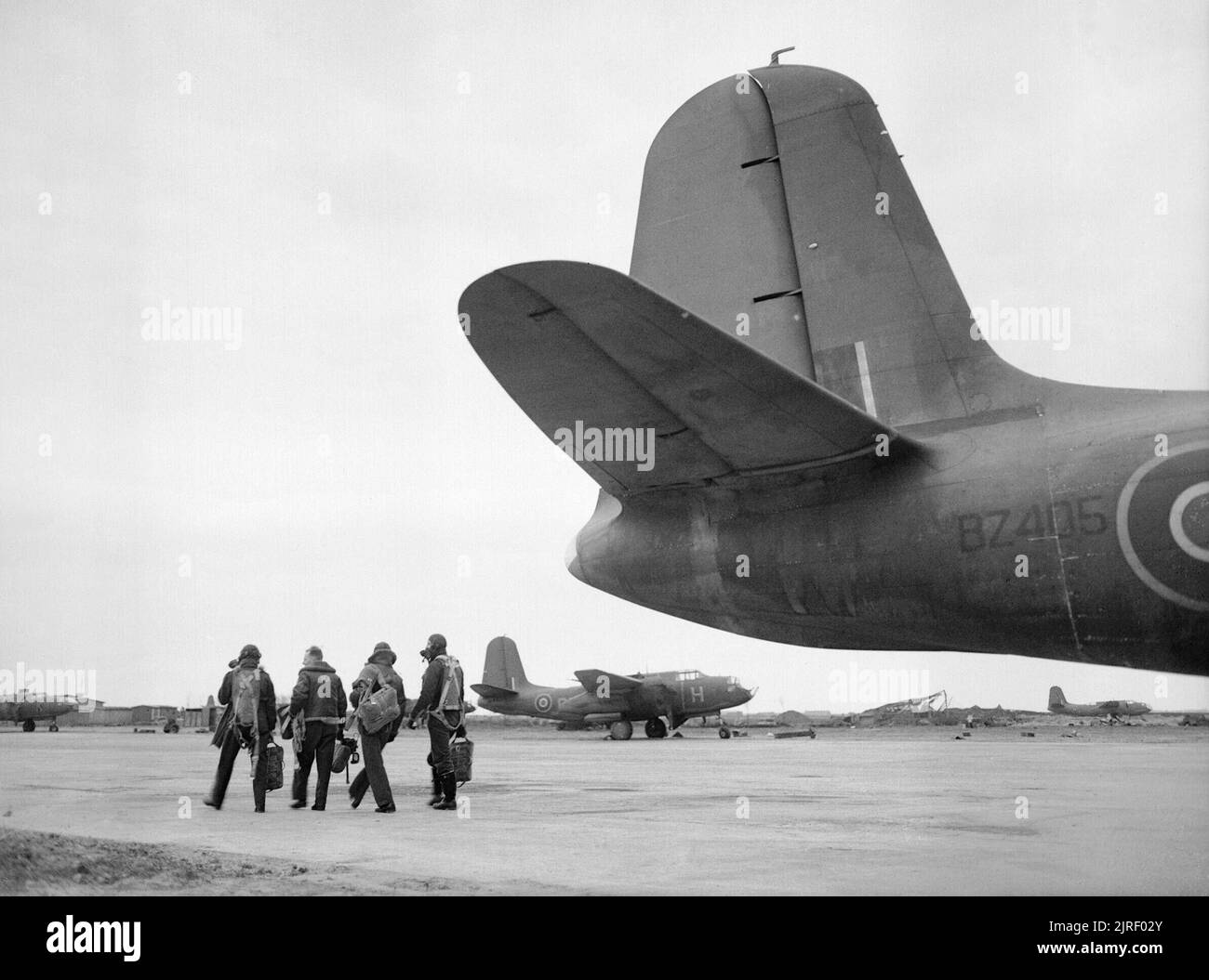 Royal Air Force- 2nd Tactical Air Force, 1943-1945. The last crew to return from the last operational mission undertaken by No. 88 Squadron RAF prior to its disbandment, walk away from their Douglas Boston Mark IV, BZ405 'RH-E', at B50/Vitry-en-Artois, France. The crew are, (left to right); Flying Officer J L Weston from Buenos Aires Flying Officer H Poole from Ilford, Essex Flying Officer B W Lawrence from Enfield, Middlesex Flight-Sergeant D Hack from Clevedon, Somerset 11 Bostons of the Squadron bombed enemy gun positions in the Emmerich area of Germany for this final mission. Stock Photo