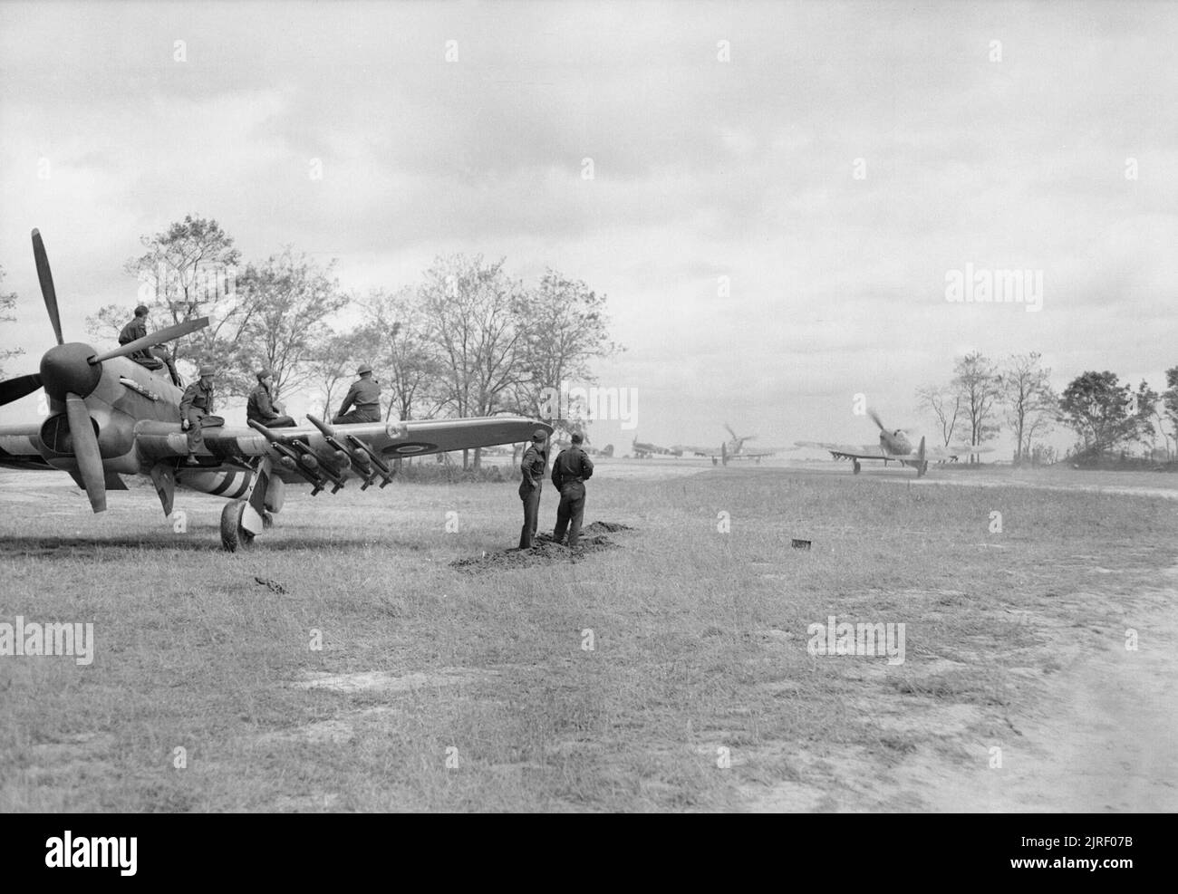 Royal Air Force- 2nd Tactical Air Force, 1943-1945. Ground crew watch Hawker Typhoon Mark IBs of No. 175 Squadron RAF as they taxi out for a sortie at B5/Le Fresne Camilly, Normandy. Stock Photo
