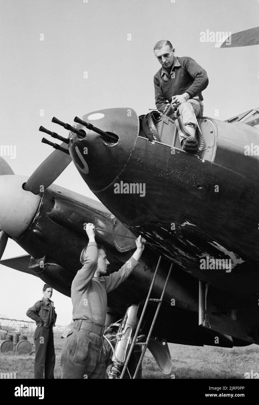 Royal Air Force- Italy, the Balkans and South-east Europe, 1942-1945. Armourers prepare a De Havilland Mosquito FB Mark VI of No. 23 Squadron RAF for night operations at Pomigliano, Italy. Feeding the ammunition belt into a Browning machine gun in the nose is Leading Aircraftman E Hurst of Cheadle, Cheshire, while Leading Airraftman T Hamill of Port Glasgow, Scotland, cleans one of the forward-firing cannon barrels. Stock Photo