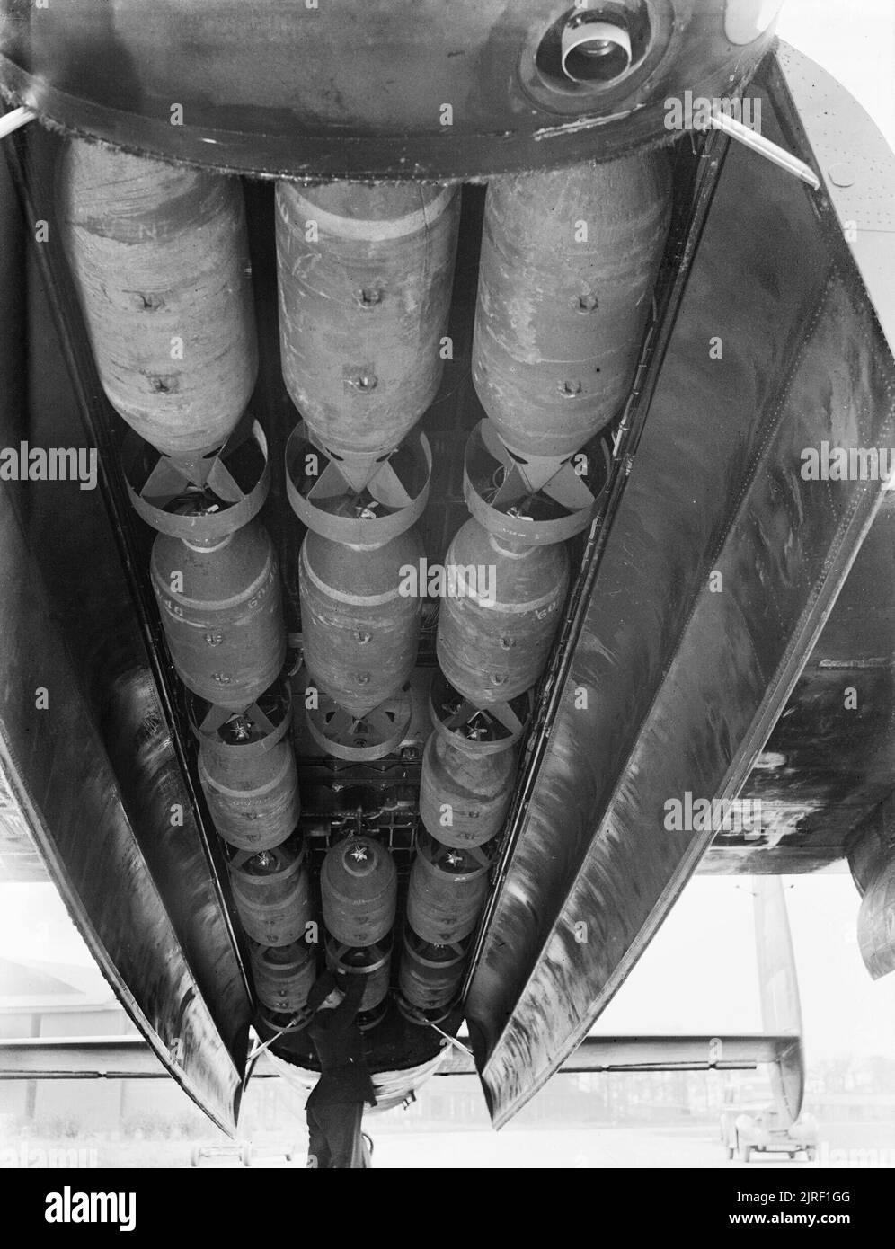 The bomb bay of an Avro Lancaster of No. 9 Squadron RAF at Bardney, Lincolnshire, loaded with 1,000lb bombs before a night raid on Stettin, 5 January 1944. The bomb load used for industrial demolition (Bomber Command executive codeword 'Abnormal'), loaded in the bomb-bay of an Avro Lancaster of No. 9 Squadron RAF at Bardney, Lincolnshire, before a night raid on Stettin, Germany. 'Abnormal' consisted of 14 x 1,000-lb MC high-explosive bombs. Stock Photo