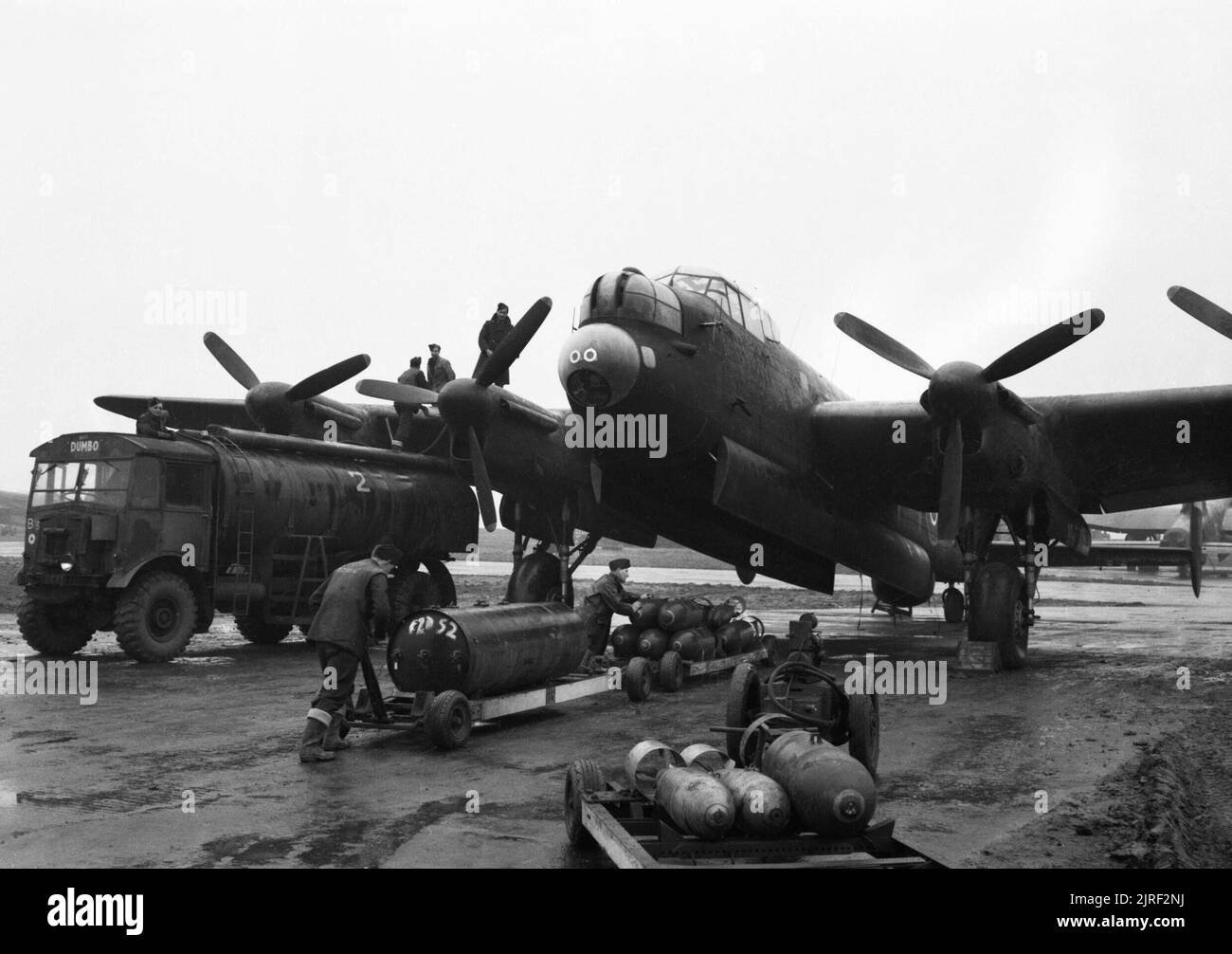 Royal Air Force Bomber Command, 1942-1945. Ground crews refuelling and bombing up an Avro Lancaster of No. 75 (New Zealand) Squadron RAF at Mepal, Cambridgeshire, for a night raid on Krefeld, Germany. The bomb load consists of a 4,000-lb HC 'cookie' and mixed 1,000-lb and 500-lb MC bombs. Stock Photo