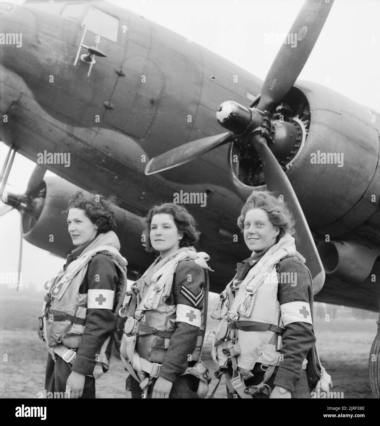 'Royal Air Force Transport Command, 1943-1945. The first WAAF nursing orderlies selected to fly on air-ambulance duties to France, standing in front of a Douglas Dakota Mark III of No. 233 Squadron RAF at B2/Bazenville, Normandy. From left to right: Leading Aircraftwoman Myra Roberts of Oswestry, Corporal Lydia Alford of Eastleigh and Leading Aircraftwoman Edna Birbeck of Wellingborough'. Stock Photo