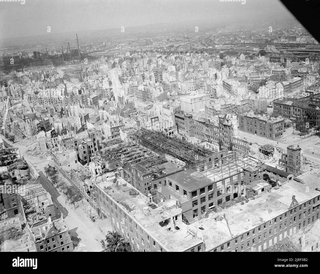 A part of Nuremberg, devastated by Allied bombing, 28 May 1945. Oblique aerial view of heavily-damaged industrial and residential buildings in Nuremberg. Visible at the centre of the photo is a multi-story above-ground air raid bunker. At the bottom of the photo, below the bunker, is the Siemens plant. Top left is the gas works in Nürnberg-Sandreuth, top right is the main station (Hauptbahnhof) Stock Photo