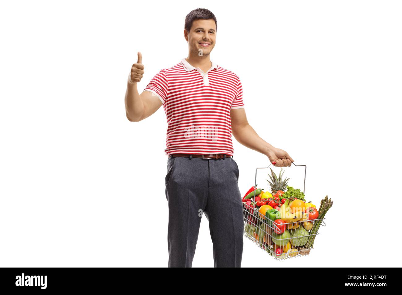 Young man smiling and holding fruits and vegetables in a shopping ...