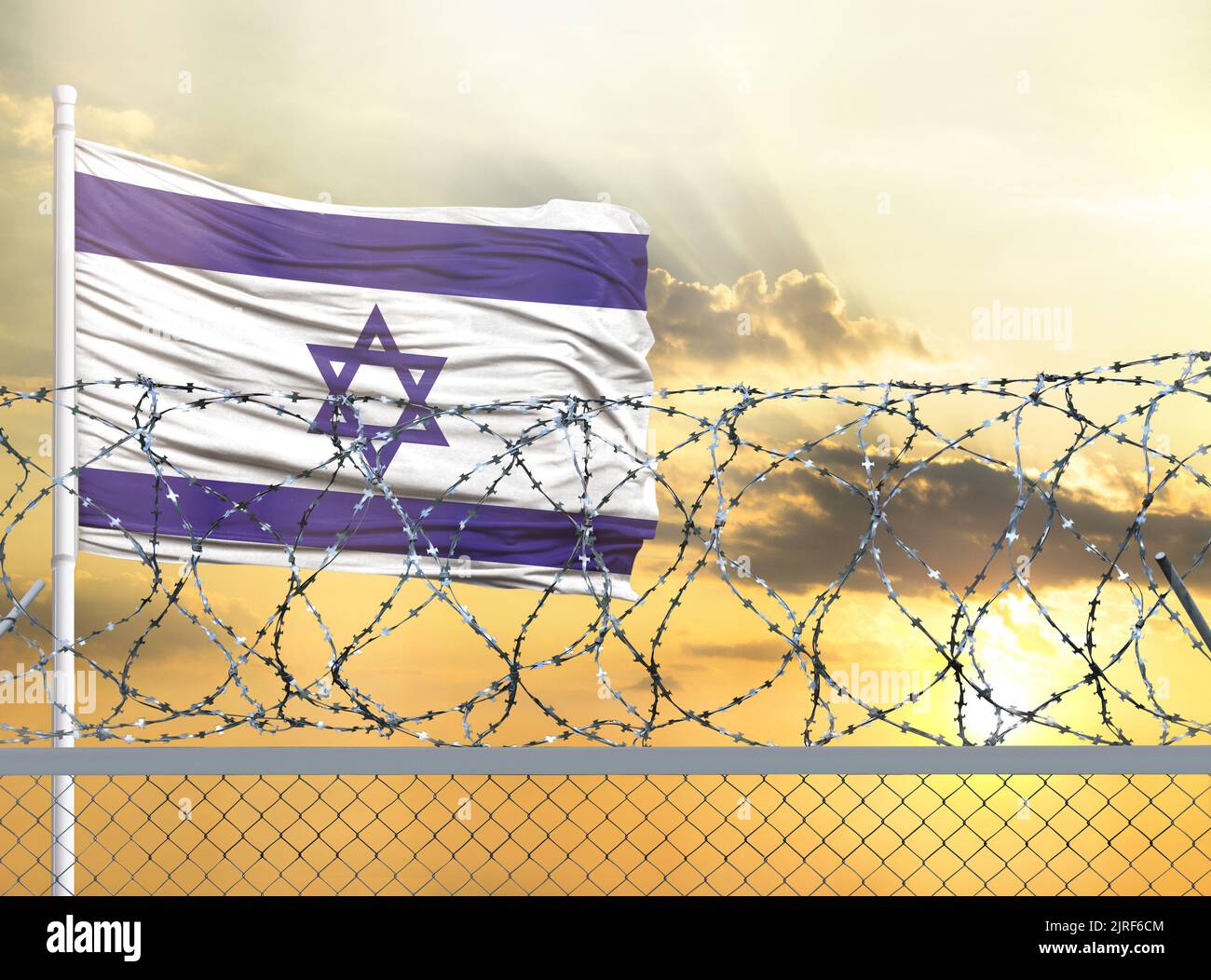 Flagpole with the flag of Israel against the sky and behind a fence ...