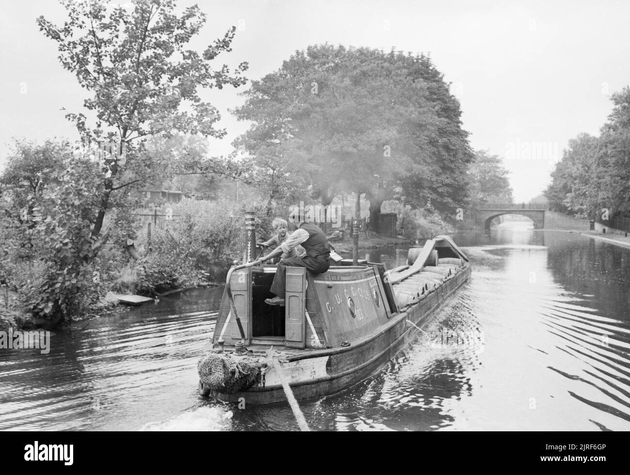 A canal boat loaded with fruit pulp travels along the leafy Regent's