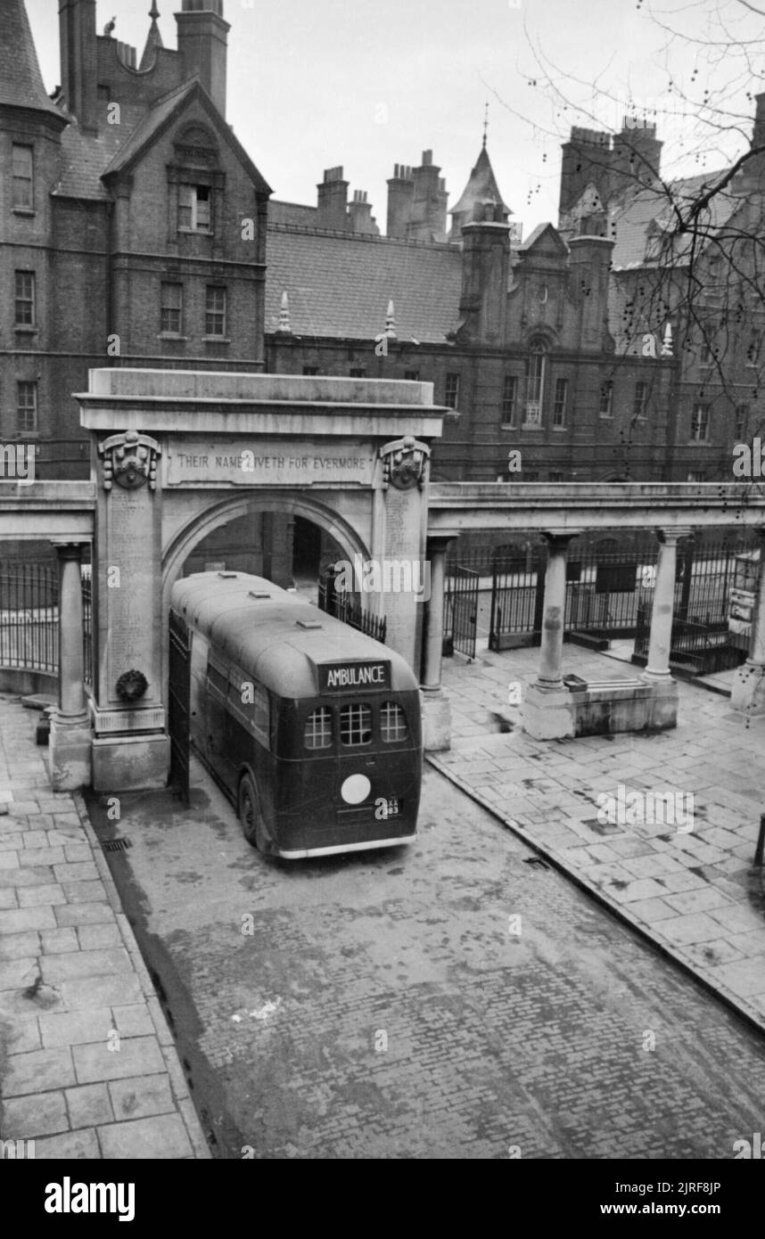 Guy's Hospital- Life in a London Hospital, England, 1941 The Green Line coach ambulance taking patients away from Guy's Hospital to base hospitals in the country drives underneath the arch at the entrance to the hospital. This arch commemorates all those from Guy's Hospital who were killed during the First World War. All patients on board the coach are from South East London. Stock Photo