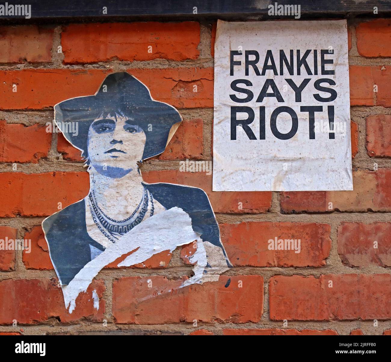 Pasted poster graffiti, Frankie says Riot!, on brick wall in a back street, Deansgate, Blackpool town centre, Lancashire, England, UK, FY1 1BN Stock Photo