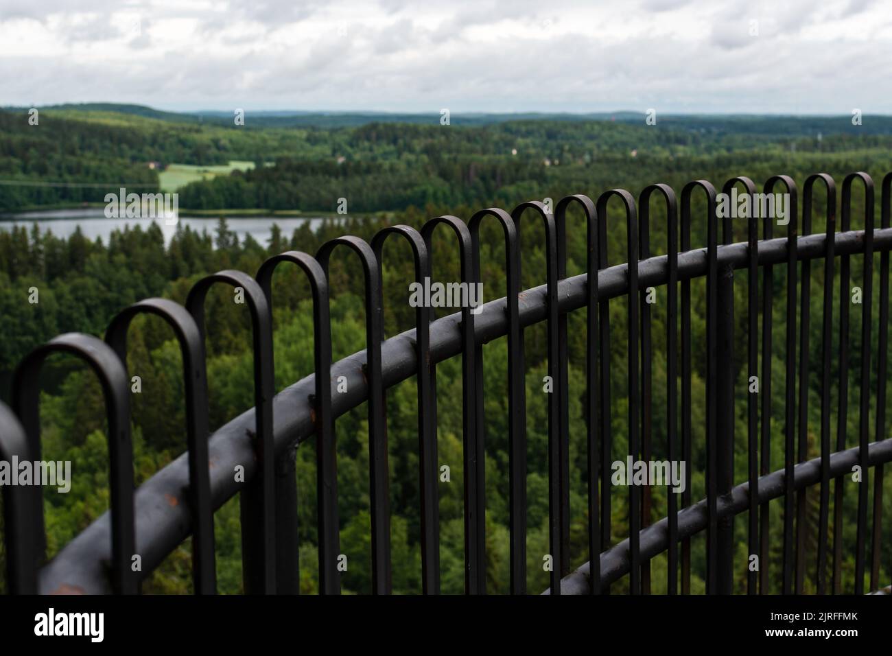 Black metal railing with out of focus nature landscape in the background, Aulanko, Finland Stock Photo