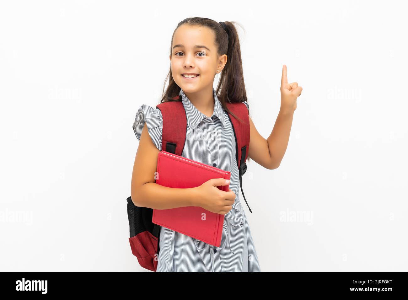 little girl isolated in white holding school book Stock Photo - Alamy
