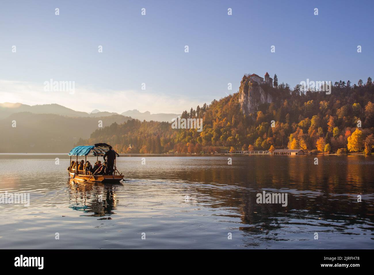 Traditional wooden boat on beautiful Bled lake, Slovenia at sunset. Stock Photo