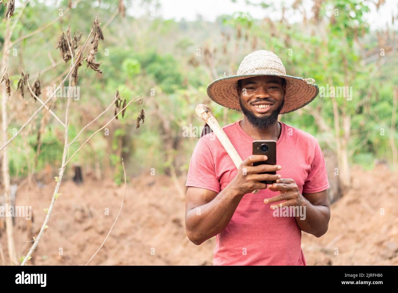 african farmer checking his phone Stock Photo