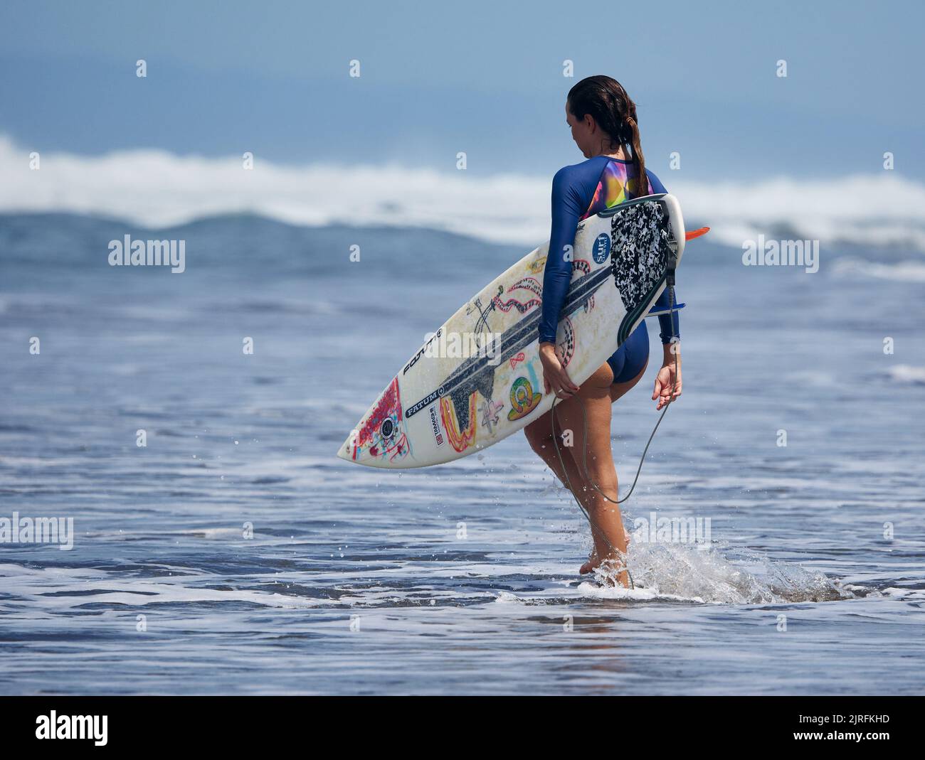 A surfer on the beach of Playa Hermosa in Costa Rica Stock Photo