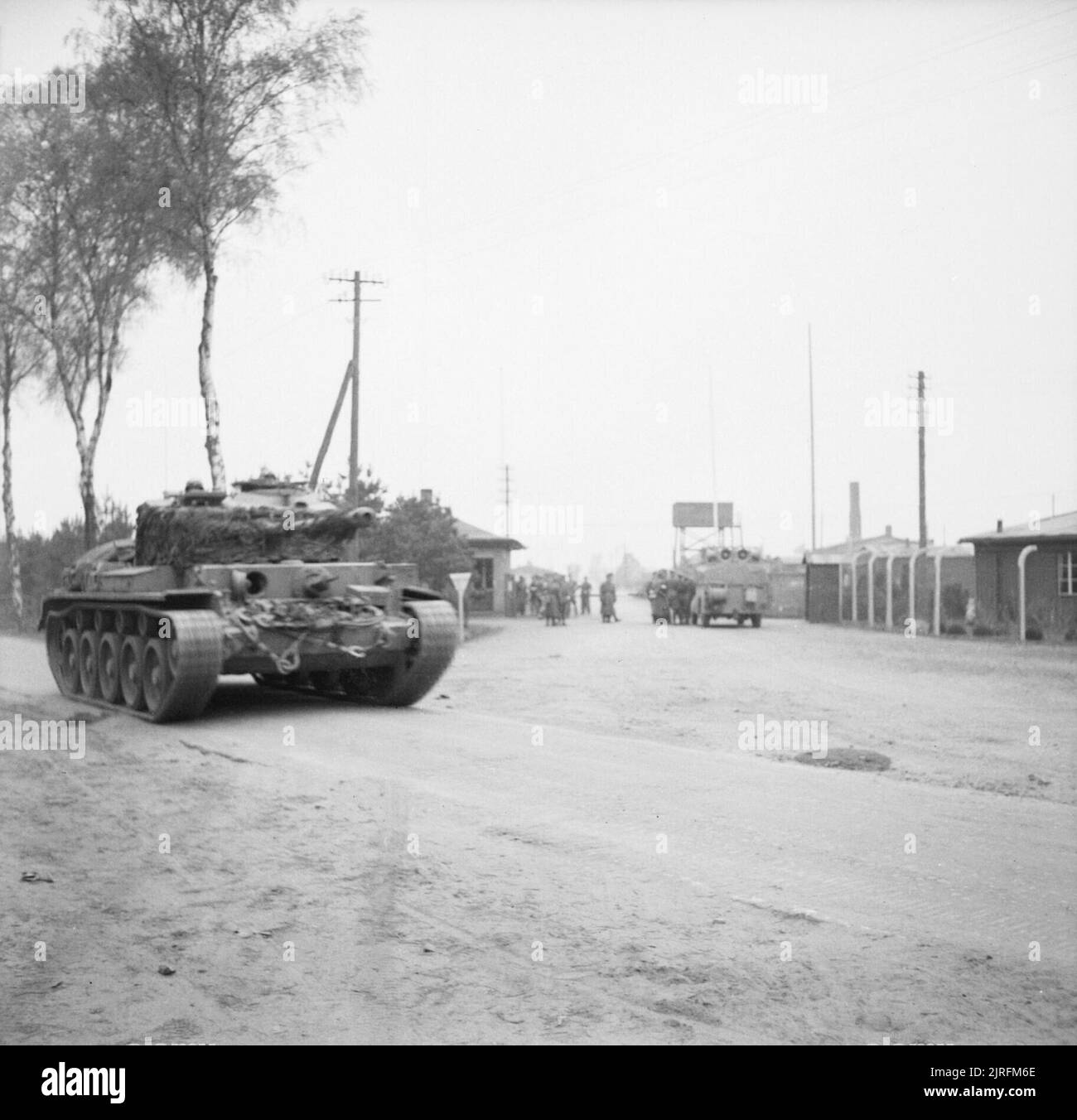 A Comet tank of 11th Armoured Division passes the camp gate at Bergen Belsen concentration camp, 15 April 1945. The British Army arrives at Belsen concentration camp. A Comet tank of 11th Armoured Division passes the camp gate. Stock Photo
