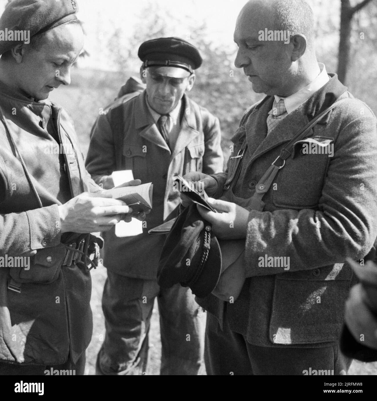 Germany Under Allied Occupation. Field Security Intelligence men interrogating Germans at the roadside near Lubeck during the search for Heinrich Himmler. During this stop and search procedure several men were found to be in possession of false identity papers. Stock Photo