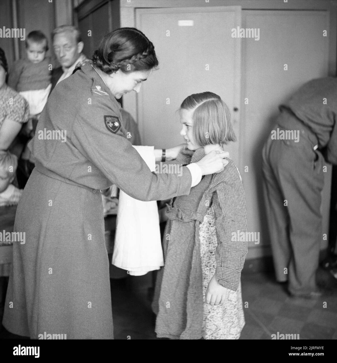 Holland After Liberation 1945 A girl is fitted out with new clothes by a Red Cross worker at a