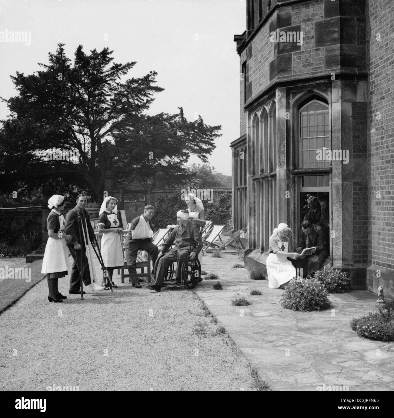 Medical Services during the Second World War A group of patients and nurses chatting together on the terrace at Longdon Hall, a large country house in Rugeley, Staffordshire, equipped by the Joint War Organisation of the Red Cross and St John as a convalescent home. The owner, Mrs F Burnett, is herself commandant of the Unit. Stock Photo