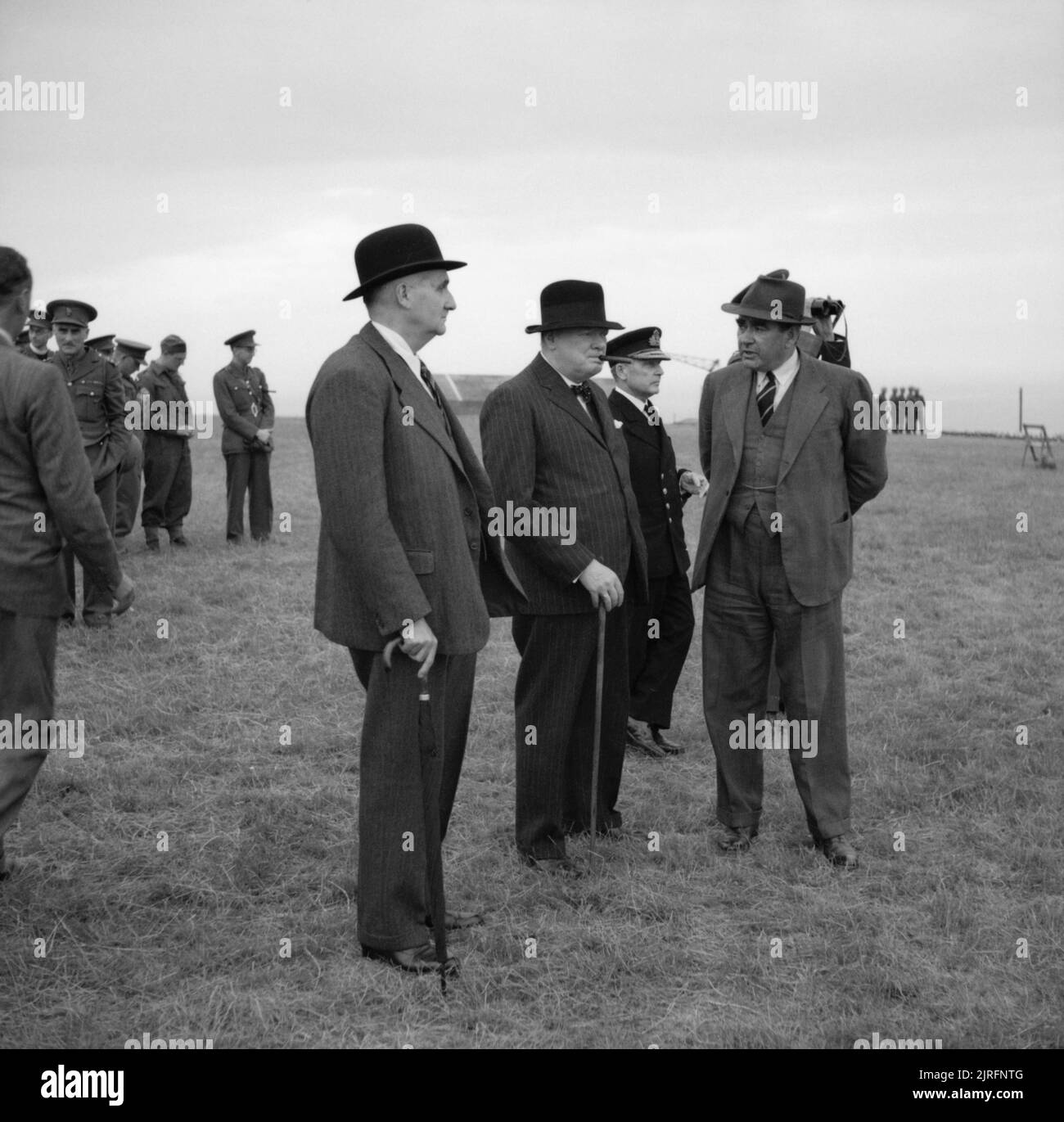 Radar and Electronic Warfare 1939-1945 Personalities: Professor F A Lindemann (later Lord Cherwell), with Winston Churchill and Dr D A Crow (Chief Superintendent Projectile Development, Ministry of Supply), with Vice Admiral Tom Phillips VCNS in the background, watching a demonstration of a secret anti-aircraft device at an experimental establishment at Holt, Norfolk. Stock Photo