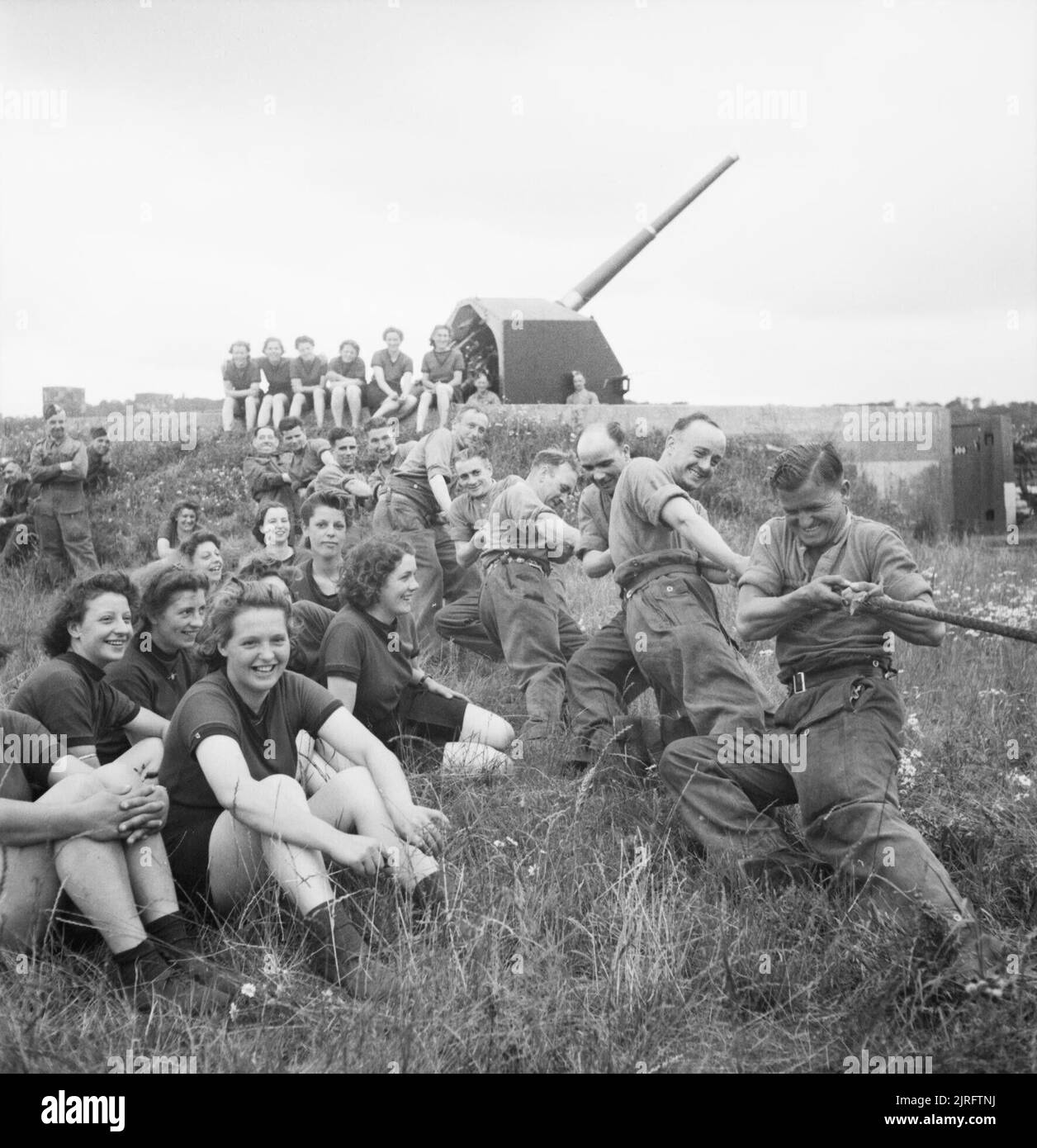 Auxiliary Territorial Service (ATS) girls watch a tug-of-war contest during a sports competition at a mixed 4.5-inch anti-aircraft battery near Edinburgh, 30 July 1943. ATS girls watch a tug-of-war contest during a sports competition at a mixed 4.5-inch anti-aircraft battery near Edinburgh, 30 July 1943. Stock Photo