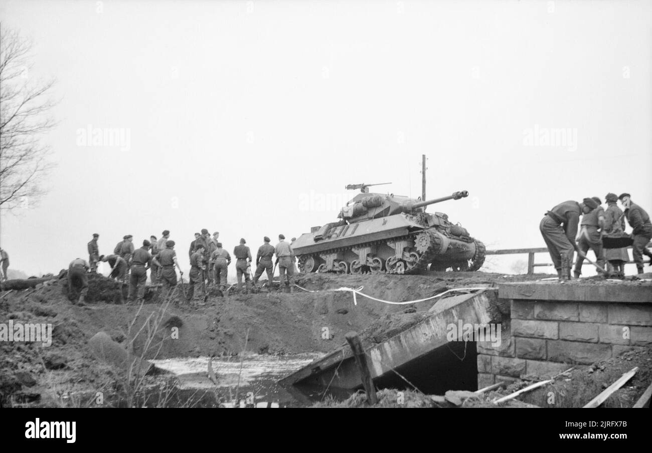 The British Army in North-west Europe 1944-45 An Achilles 17-pdr self-propelled gun passes Royal Engineers repairing a bridge during the advance on Coesfeld, 30 March 1945. Stock Photo