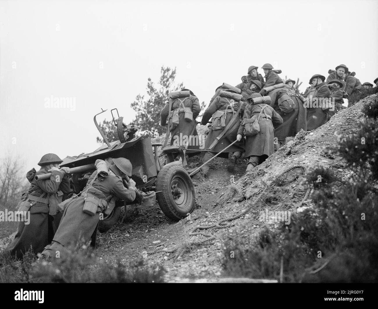 The British Army in the United Kingdom 1939-45 Gunners of 20th Anti-Tank Regiment, 3rd Infantry Division, haul a 2-pdr anti-tank gun up a steep slope during training at Verwood in Dorset, 22 March 1941. Stock Photo