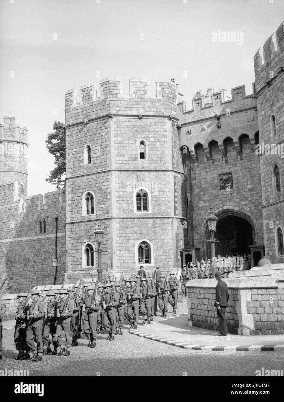 The Castle Guard, formed from members of the training battalion, Grenadier Guards, leaving the main entrance of Windsor Castle on the way to Victoria Barracks, 30 June 1940. The Castle Guard, formed from members of the training battalion, Grenadier Guards, leaving the main entrance of Windsor Castle on the way to Victoria Barracks in Windsor, 30 June 1940. Stock Photo