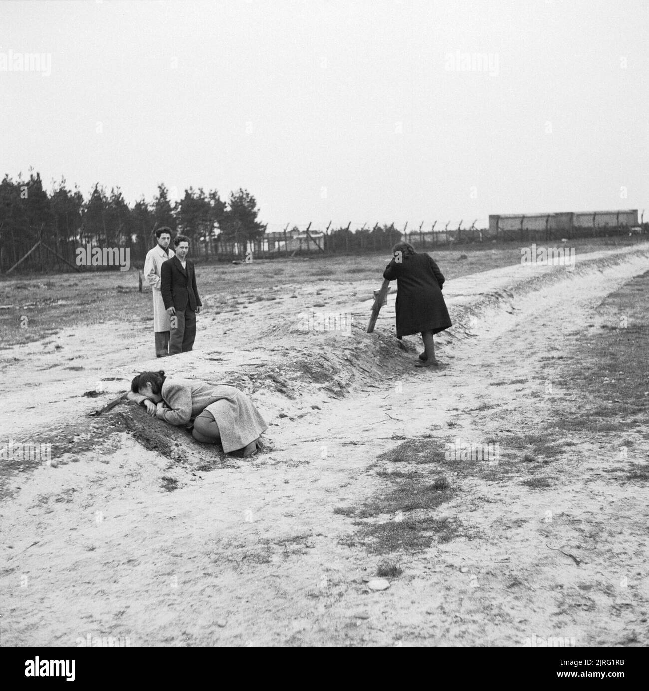 The First Anniversary of the Liberation of Bergen-belsen Concentration Camp, April 1946 Two former women inmates weep over one of the mass graves. Stock Photo