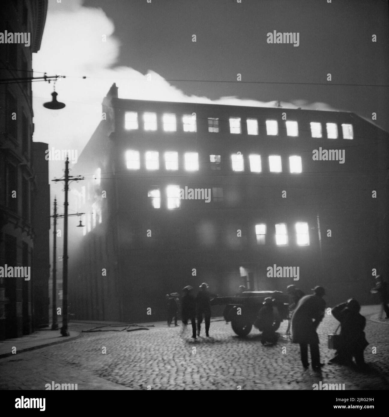 The Manchester Blitz Buildings surrounding a bus station in Manchester burning after a German air raid on the night of 23 December 1940. Stock Photo