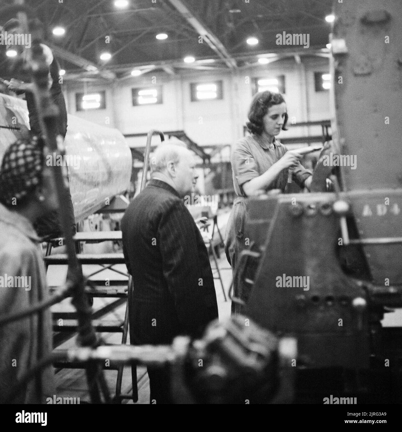 Winston Churchill watches a female riveter at work on a Supermarine Spitfire at the Castle Bromwich factory in Birmingham, 28 September 1941. The Prime Minister Winston Churchill observes a female riveter working on a Supermarine Spitfire at the Castle Bromwich factory in Birmingham, England, on 28 September 1941. Stock Photo