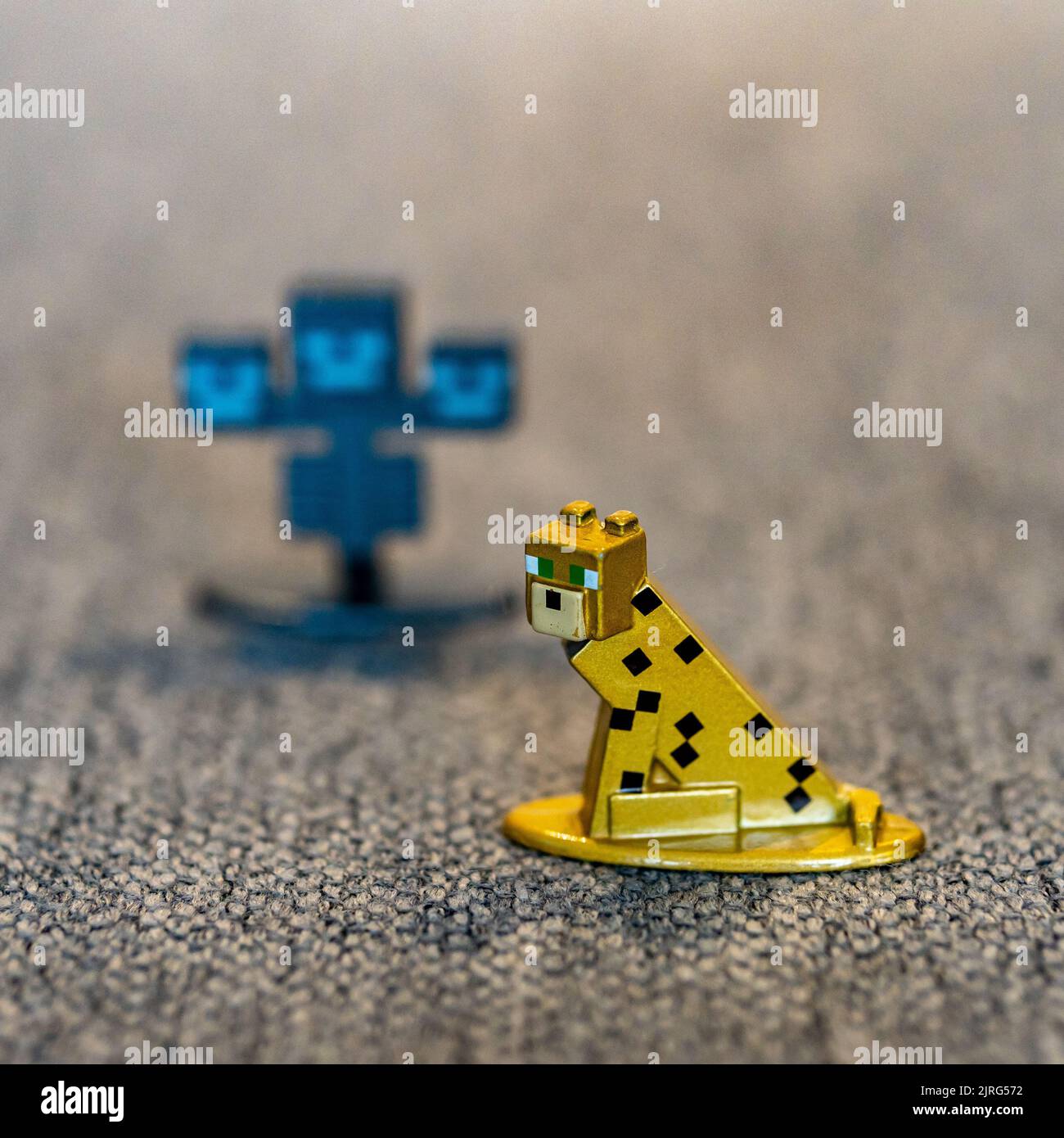 A closeup shot of a Minecraft ocelot cat toy figurine made of metal. Stock Photo