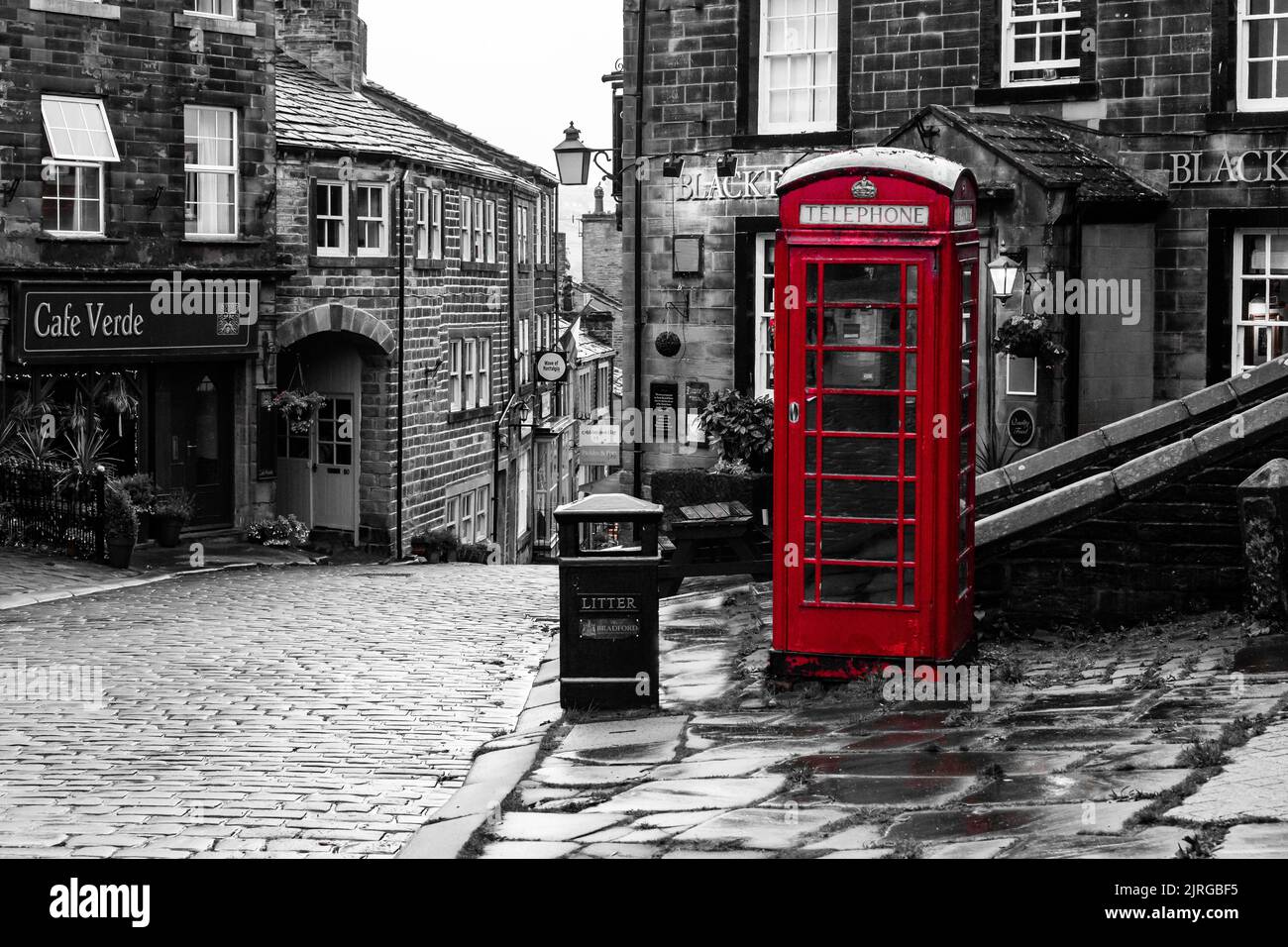 A red K6 telephone box against a monochrome background in Haworth, Yorkshire, England. Stock Photo